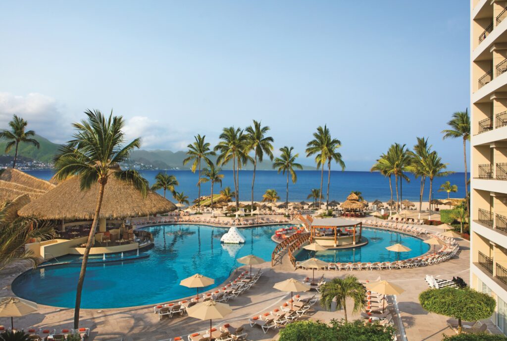 Alberca del Sunscape Puerto Vallarta con palmeras, ideal para un viaje con niños con HostpVallarta.